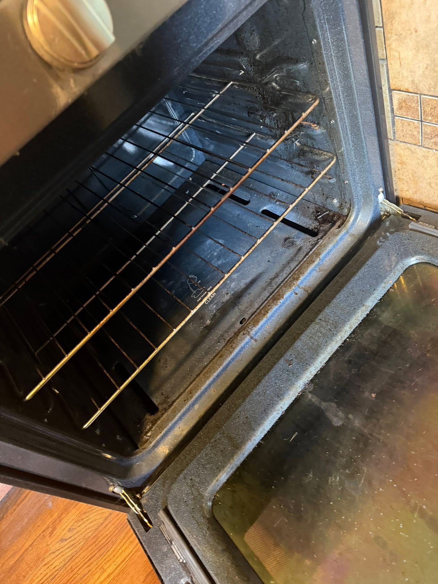 Second oven before cleaning, rust and burnt residue throughout